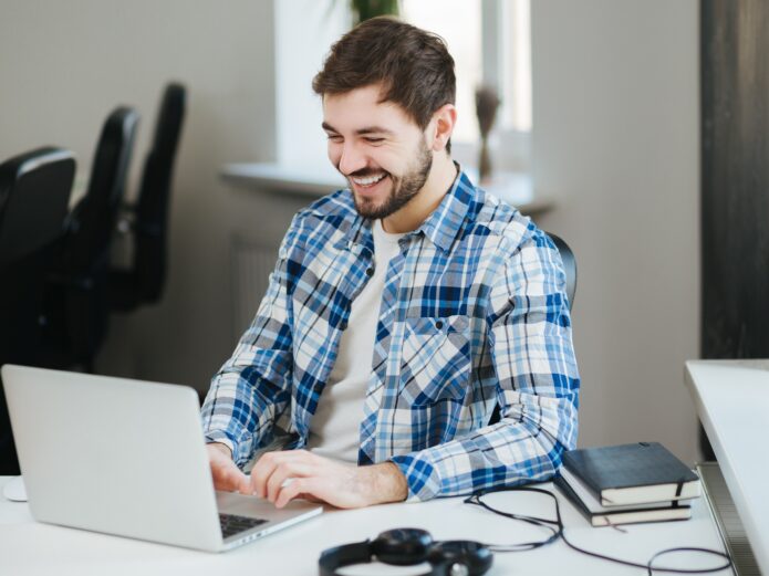 Happy man working on laptop