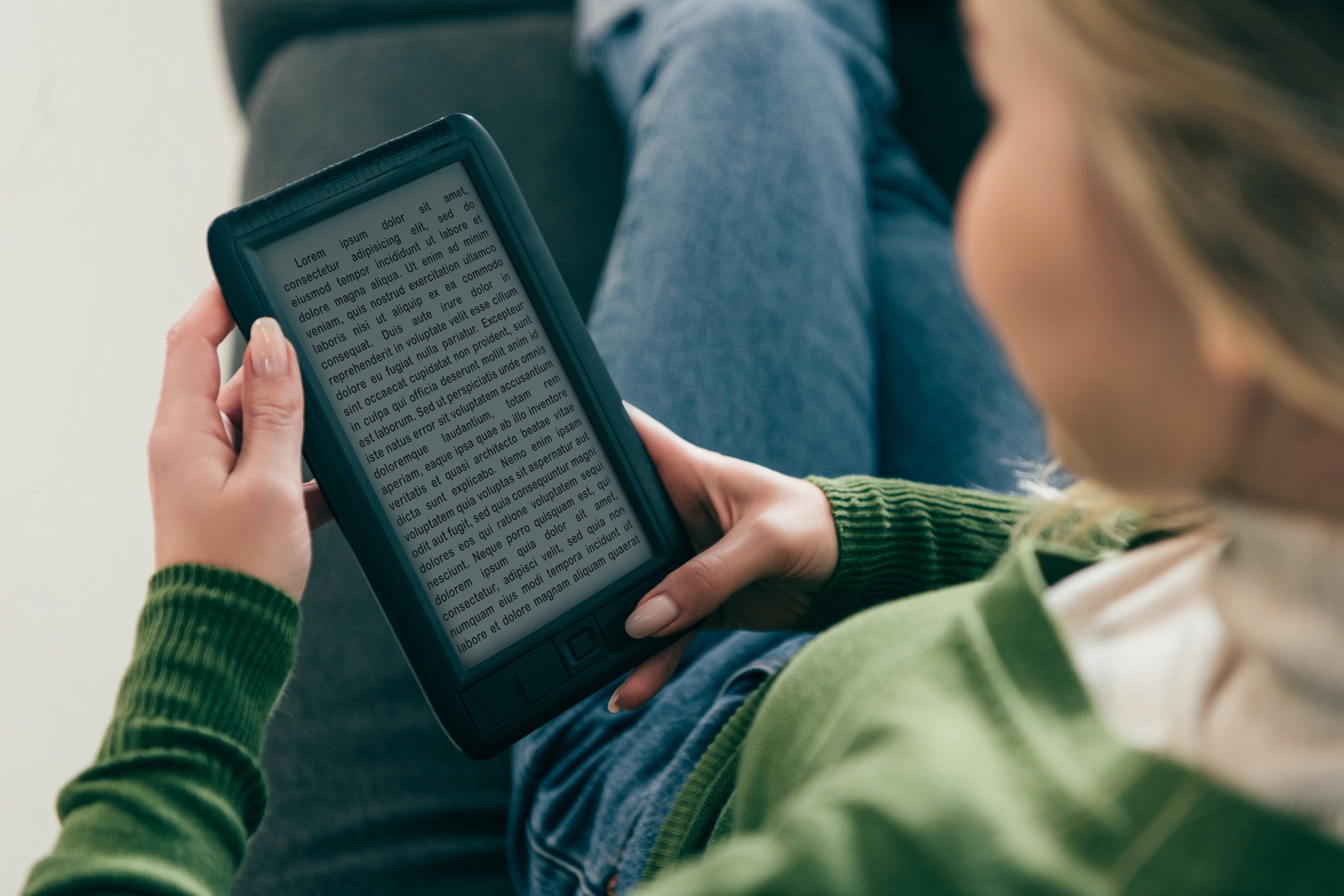 selective focus of woman studing with ebook while sitting on sofa