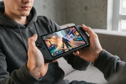 Homme tenant une console portable Sony avec écran OLED dans un appartement moderne
